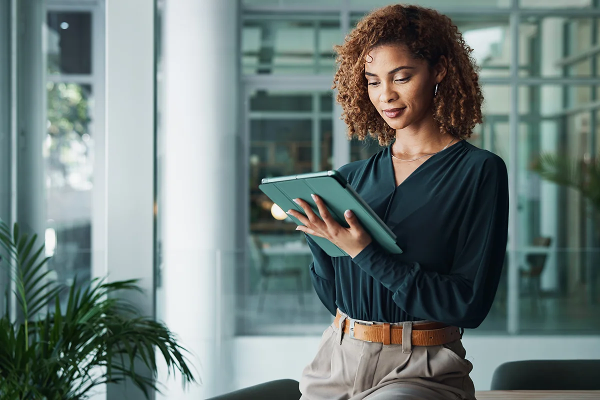 A small business owner holding a tablet in a modern office, showing the concept of software and application strategies